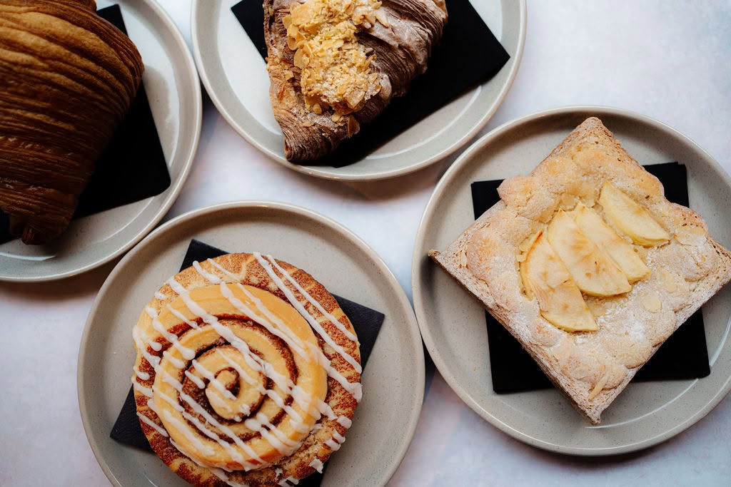 Cinnamon swirl, croissant and apple frangipane slice on plates at Brown Bag Cafe Skipton